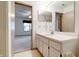 Bright bathroom features single sink vanity and mirror with door to bedroom at 5839 Quail Run Dr, Indianapolis, IN 46237