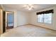 Spacious bedroom with neutral carpet, ceiling fan, and easy access to other rooms at 5839 Quail Run Dr, Indianapolis, IN 46237