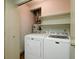 Functional laundry room with washer, dryer, and convenient shelving for storage at 5839 Quail Run Dr, Indianapolis, IN 46237