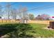 A backyard with grass, wooden fence, firepit, storage shed, and access to the deck at 598 Collier St, Columbus, IN 47201