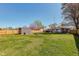 A spacious backyard with grass, wooden fence, firepit, storage shed, and deck at 598 Collier St, Columbus, IN 47201