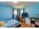 Bedroom with bright blue walls, wood floors, and natural light at 598 Collier St, Columbus, IN 47201