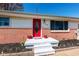 A bright red front door is the focal point of the front porch and surrounding flower beds at 598 Collier St, Columbus, IN 47201