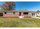 Charming ranch-style home boasts a brick facade, bright red door, and beautifully manicured front yard at 598 Collier St, Columbus, IN 47201