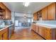 Open kitchen with wood cabinets, stainless dishwasher, and connecting dining area with backyard access at 598 Collier St, Columbus, IN 47201