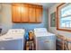 Laundry room with washer, dryer, shelving, and natural light from the window at 598 Collier St, Columbus, IN 47201