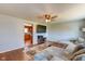 Bright living room featuring a large sectional sofa, ceiling fan, hardwood floors, and TV at 598 Collier St, Columbus, IN 47201