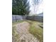 Fenced backyard featuring a brick patio, mature trees, and a charming fire pit at 6011 Mcclellan Ct, Indianapolis, IN 46254