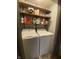 Efficient laundry room featuring front load washer and dryer, complemented by convenient wooden shelving at 6011 Mcclellan Ct, Indianapolis, IN 46254