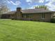 Expansive green lawn features a stone home with chimney and a screened-in porch at 616 Elbow Bend Blvd, Greenwood, IN 46142