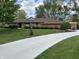 Charming stone home with a well manicured front yard and an expansive driveway, situated under a bright sky at 616 Elbow Bend Blvd, Greenwood, IN 46142