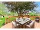 Wooden deck with outdoor dining setup, grill, and a view of the grassy backyard and mature trees at 6164 Parrington Dr, Indianapolis, IN 46236