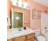 A bathroom with a peach colored wall with a single sink vanity and standard shower and toilet combination at 6164 Parrington Dr, Indianapolis, IN 46236