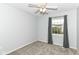 Cozy bedroom with neutral walls, gray carpet, and a ceiling fan with great natural light from the window at 6164 Parrington Dr, Indianapolis, IN 46236