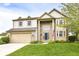 Charming two-story home with a well-maintained lawn, an attached two-car garage, and a classic facade at 6164 Parrington Dr, Indianapolis, IN 46236