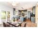 Bright kitchen boasts grey cabinets, island with seating, stainless appliances, and access to the back deck through sliding door at 6164 Parrington Dr, Indianapolis, IN 46236