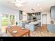 Bright kitchen with updated appliances, tile flooring, a center island, and breakfast nook near sliding glass door at 6164 Parrington Dr, Indianapolis, IN 46236