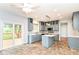 Well-lit kitchen with an island, gray cabinets, and a sliding door to the deck at 6164 Parrington Dr, Indianapolis, IN 46236