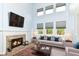 Sun-lit living room featuring a fireplace, vaulted ceilings, and large windows at 6164 Parrington Dr, Indianapolis, IN 46236