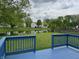 Backyard view showing a blue deck overlooking a scenic pond and lush landscaping at 621 Jack Pine Ct, Indianapolis, IN 46224