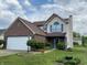 Charming two-story home with brick and vinyl siding, a well-manicured lawn, and a two car garage at 621 Jack Pine Ct, Indianapolis, IN 46224