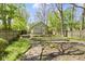 Landscaped backyard with a wooden deck and pergola, lush greenery, and wooden privacy fence at 6307 Broadway St, Indianapolis, IN 46220