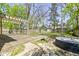 Backyard wooden deck with pergola, outdoor tub, green shed, surrounded by trees and grass at 6307 Broadway St, Indianapolis, IN 46220
