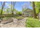 Fenced backyard featuring garden beds, lawn, patio, pergola-covered deck, and mature trees at 6307 Broadway St, Indianapolis, IN 46220