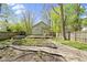 Spacious backyard with a wood deck, garden beds, and a lovely green house exterior view at 6307 Broadway St, Indianapolis, IN 46220