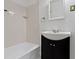 Bathroom featuring tiled shower/tub and a black vanity with white sink at 6307 Broadway St, Indianapolis, IN 46220