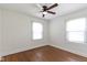 Bright bedroom featuring hardwood floors, a ceiling fan, and white trim around the windows at 6307 Broadway St, Indianapolis, IN 46220
