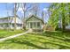 Inviting green home with a sunroom and a well-kept grassy yard at 6307 Broadway St, Indianapolis, IN 46220
