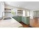 Cozy kitchen with green cabinets, stainless steel appliances, and wooden shelving at 6307 Broadway St, Indianapolis, IN 46220