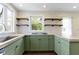 Bright kitchen featuring green cabinets, a center island, and sleek countertops at 6307 Broadway St, Indianapolis, IN 46220