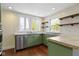 Modern kitchen with stainless steel appliances, green cabinetry, and natural light at 6307 Broadway St, Indianapolis, IN 46220