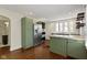 Stylish kitchen boasting green cabinetry, stainless steel appliances, and hardwood floors at 6307 Broadway St, Indianapolis, IN 46220