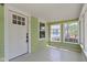 Cozy sunroom with a white door, paneled ceiling, and multiple windows at 6307 Broadway St, Indianapolis, IN 46220
