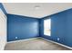 Cozy bedroom with a carpeted floor, blue accent wall, and natural light at 6827 Fallen Leaf Dr, Whitestown, IN 46075