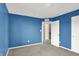 A simple bedroom with a blue accent wall and a view into an adjoining room at 6827 Fallen Leaf Dr, Whitestown, IN 46075
