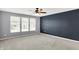 Bedroom with a dark accent wall and a row of three windows at 6827 Fallen Leaf Dr, Whitestown, IN 46075