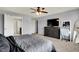 Spacious bedroom showcasing a ceiling fan, TV, full-length mirror, and a vanity with lighted mirror at 6827 Fallen Leaf Dr, Whitestown, IN 46075