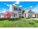 Beautiful two-story home with a lush green lawn and a lovely blooming tree in the front yard at 6827 Fallen Leaf Dr, Whitestown, IN 46075