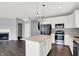 This kitchen features a center island, fireplace, stainless steel appliances, and sleek finishes at 6827 Fallen Leaf Dr, Whitestown, IN 46075