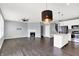 Open-concept living space featuring dark wood floors, fireplace, modern lighting, and updated kitchen with island at 6827 Fallen Leaf Dr, Whitestown, IN 46075
