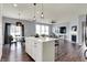 Open-concept kitchen and living area with modern lighting and a fireplace at 6827 Fallen Leaf Dr, Whitestown, IN 46075