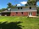 Spacious backyard view highlighting a brick home with a deck, set against a bright blue sky and green lawn at 7140 Avalon Trail Dr, Indianapolis, IN 46250