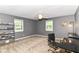 This room features gray walls, neutral carpet, two windows, and a ceiling fan at 7140 Avalon Trail Dr, Indianapolis, IN 46250