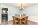 Charming dining room with a wooden table set for four, featuring a stylish light fixture and wainscoting at 7140 Avalon Trail Dr, Indianapolis, IN 46250