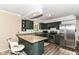 Stylish kitchen with stainless steel appliances, granite countertops, and dark green cabinetry at 7140 Avalon Trail Dr, Indianapolis, IN 46250