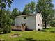 The back of the house is surrounded by lush greenery, offering a private outdoor space and deck at 728 W 300 N, Anderson, IN 46011
